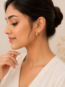 Gold wide cuff hoop earrings with brushed gold finish on a soft neutral background.