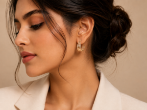 Gold triple layer hoop earrings with polished finish displayed on a soft neutral luxury background.