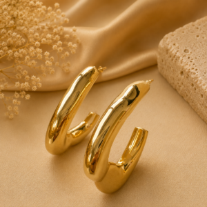 Chunky gold teardrop hoop earrings with a polished mirror finish and modern sculptural design.