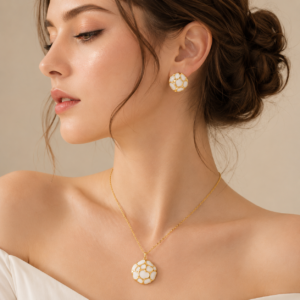 Woman wearing a turquoise enamel pendant necklace and matching stud earrings with gold-tone detailing in a luxury fashion photoshoot.