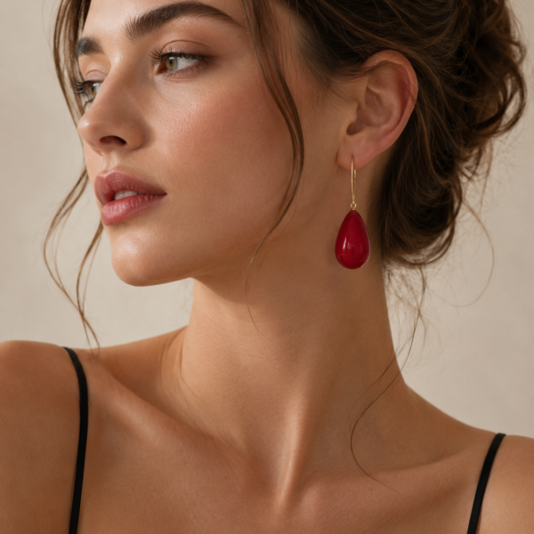 Foreign fashion model wearing elegant pearl teardrop drop earrings with gold-tone hook design in a luxury studio photoshoot.
