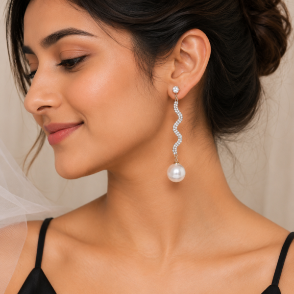 Woman wearing elegant gold pearl drop earrings with a modern gold-plated design and white pearl accents.