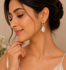 Woman wearing elegant gold pearl drop earrings with a modern gold-plated design and white pearl accents.