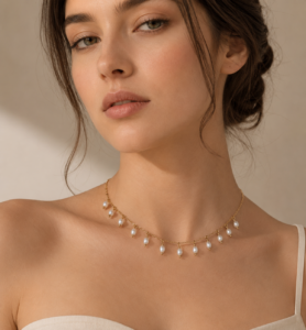 Layered gold-tone necklace featuring delicate dangling pearl charms and elegant chain detailing