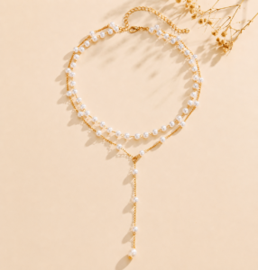 Luxury multi-layer pearl necklace with silver-tone accent beads and a crystal drop pendant displayed in an elegant flat-lay product photography setting.