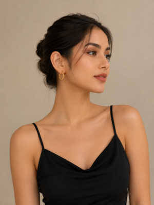Elegant gold twisted hoop earrings with braided rope detailing displayed on a neutral stone background.