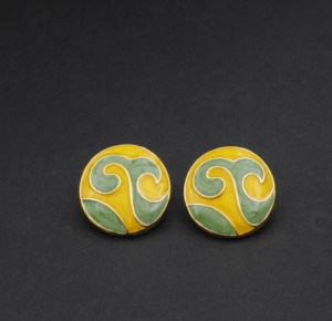 Woman wearing yellow and green enamel round stud earrings with gold-tone detailing