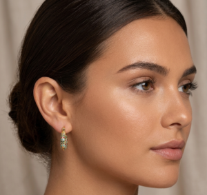 Woman wearing luxury gold-tone crystal hoop earrings with sparkling stone detailing