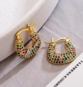 Woman wearing luxury gold-tone crystal hoop earrings with sparkling stone detailing